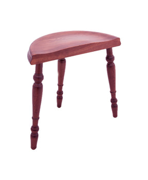 A wooden three-legged Kromski Spinning Stool from Kromski North America, featuring a semi-circular seat and turned legs, is shown against a white background. The stool, reminiscent of traditional spinning wheel stools, boasts a polished reddish-brown finish that highlights its quality woodworking.