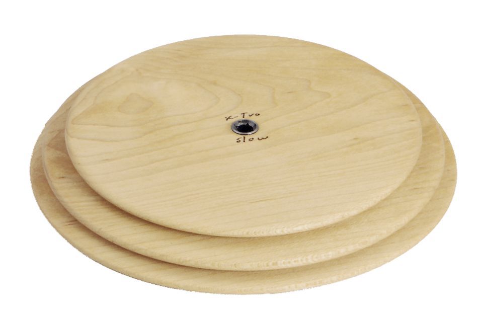 Three stacked, round wooden balance boards with a central pivot point. The middle board has the words "Schacht Whorl" and "Slow" written on it in black ink near the pivot. The boards are light-colored, showcasing natural wood grain patterns. This product is from Schacht Spindle Co.