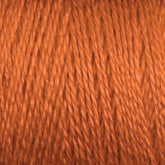 Close-up image of a spool of Maurice Brassard 16/2 Bamboo Yarn in burnt orange, showcasing the texture and twist of the thin, shiny fibers tightly wound together. This sustainable material offers an antibacterial quality that's both practical and eco-friendly.