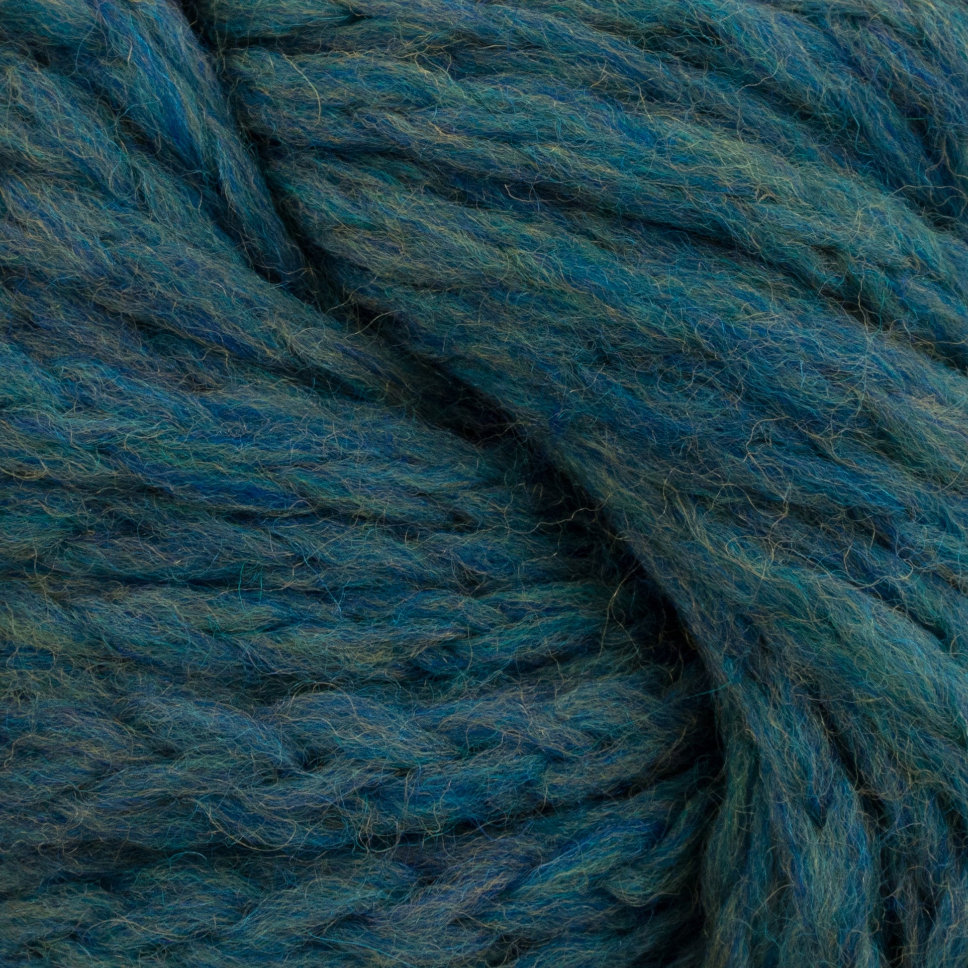 Close-up image of the thick, textured Ushya Yarn by Mirasol in shades of teal and green from Knitting Fever/Euro Yarns, showing its intertwined fibers and soft, fuzzy surface. This bulky chainette merino wool is perfect for cozy projects.