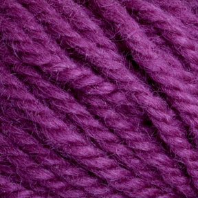 Close-up image of thick strands of Halcyon Yarn Classic Rug Wool from Caledonian Dye Works, hand-dyed in a rich, vibrant purple. The texture is soft and slightly fuzzy, with the yarn twisted in a uniform pattern—perfect for rug weavers looking to create stunning pieces.