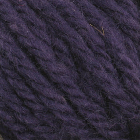 Close-up image of Halcyon Yarn Classic Rug Wool by Caledonian Dye Works. The thick, purple strands appear soft and slightly fuzzy, with tightly twisted fibers creating a textured pattern. Rug weavers will appreciate the deep, rich purple of this wool, featuring subtle variations in shading due to its hand-dye process.