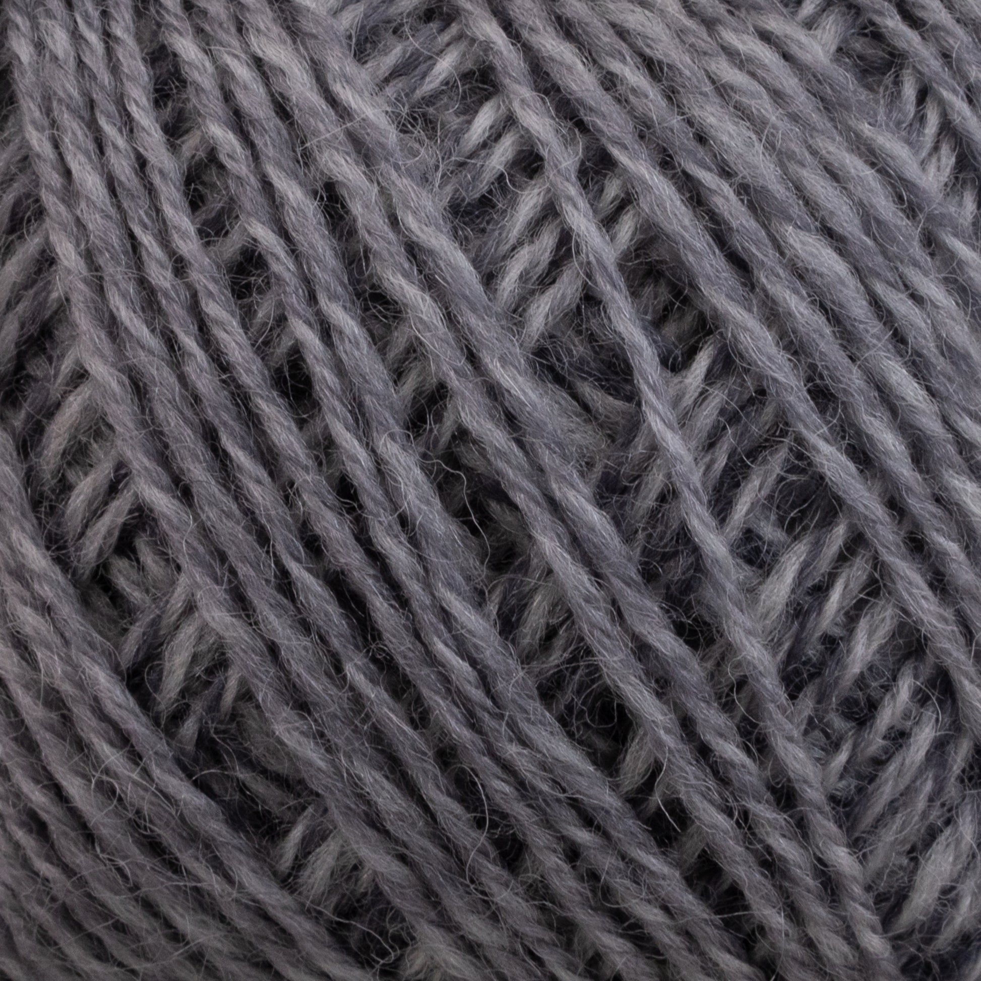 Close-up of a ball of Knitting Fever Painted Desert Yarn by Euro Yarns, showcasing the detailed texture with tightly wound strands. The yarn fibers appear to be soft and slightly fuzzy, indicating a wool or wool-blend material. Long color changes offer a myriad of possibilities for lightweight accessories, emphasizing the intricate crisscross patterns of the threads.