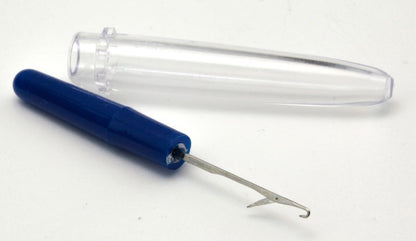 The Knit Picker by Dritz from Notions, featuring a blue handle, commonly used as a snag repair tool, is shown alongside its transparent plastic cover, both placed on a pristine white surface.