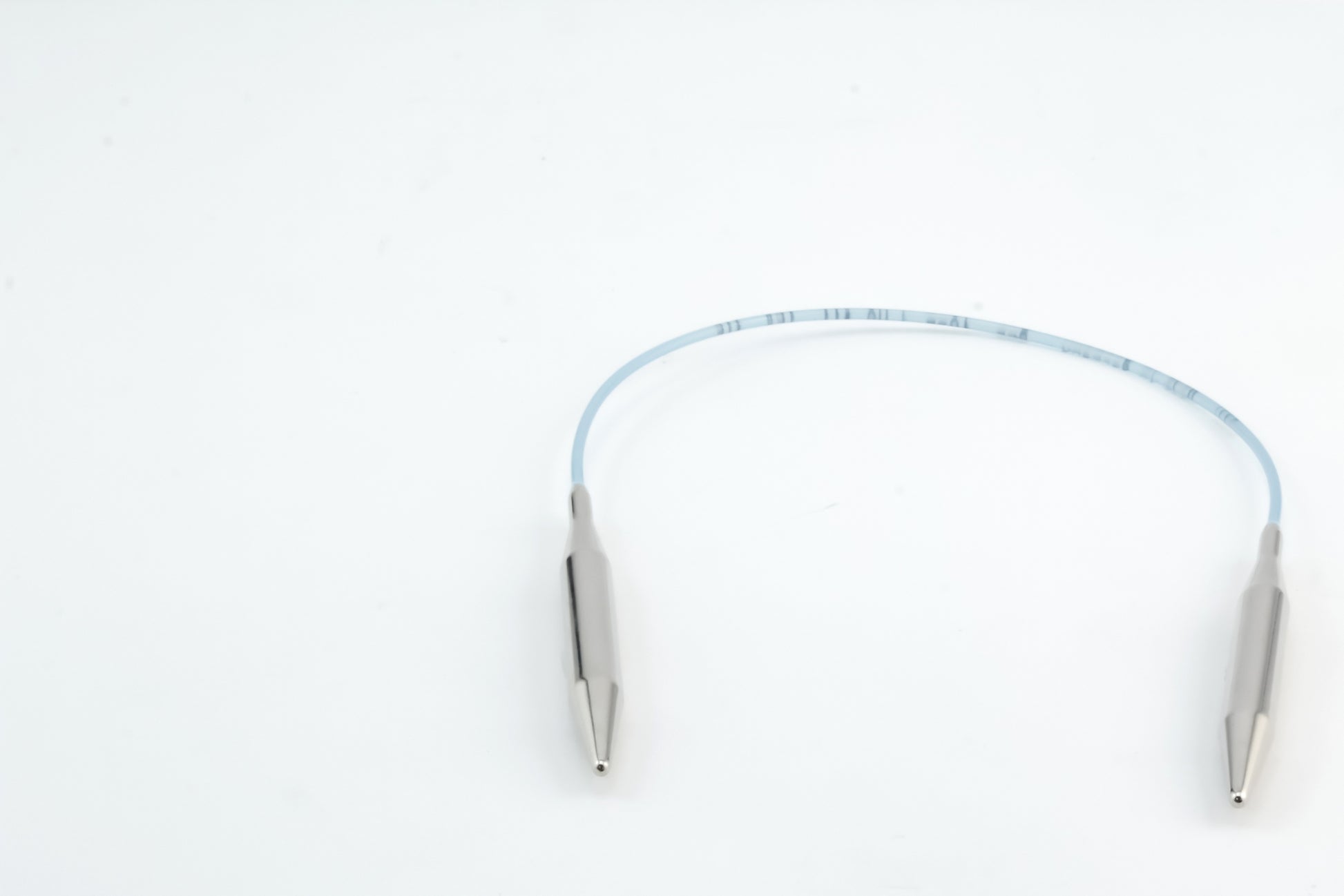 The image showcases the Addi Turbo Circular Knitting Needles by Skacel, featuring a looped metal cable with smooth, curved ends set against a plain white background. The cable appears flexible and is likely designed for specialized tasks, closely resembling the high-quality circular needles in the Addi Turbo range.