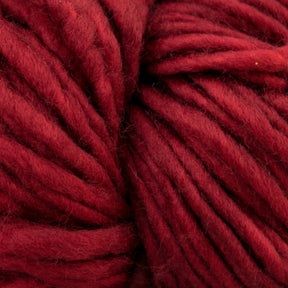 Close-up image of thick, soft, deep red yarn, showing its texture and fibers. The superwash bulky yarn is tightly coiled, filling the entire frame, highlighting its rich color and plush appearance—a true testament to Malabrigo Yarn's Mecha collection and their impeccable kettle dyed craftsmanship.