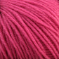 Close-up image of a ball of soft, pink Baby Blatt yarn by Anny Blatt, showing the texture of the intertwined strands. The yarn appears to be loosely twisted and has a matte finish with fine fibers visible on the surface. This machine washable, fingering weight yarn by Essentially Felt Studio & Fine Yarn is perfect for delicate projects.