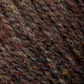 Close-up image of multi-colored, textured sport weight yarn featuring an intricate blend of brown, red, blue, and green fibers. The yarn appears thick and woolen, showcasing a mix of natural and dyed fibers from Bartlettyarns' Bartletts Maine Wool - Sport collection.