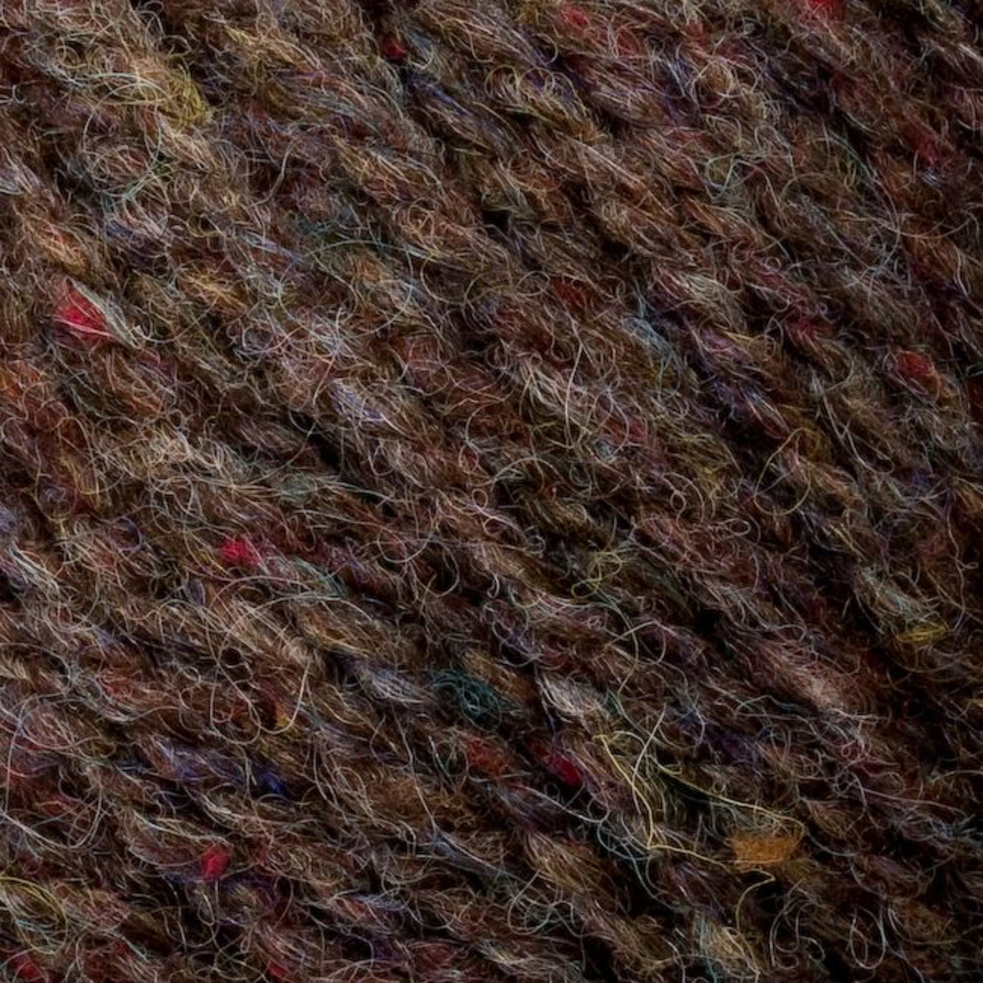 Close-up image of multi-colored, textured sport weight yarn featuring an intricate blend of brown, red, blue, and green fibers. The yarn appears thick and woolen, showcasing a mix of natural and dyed fibers from Bartlettyarns' Bartletts Maine Wool - Sport collection.