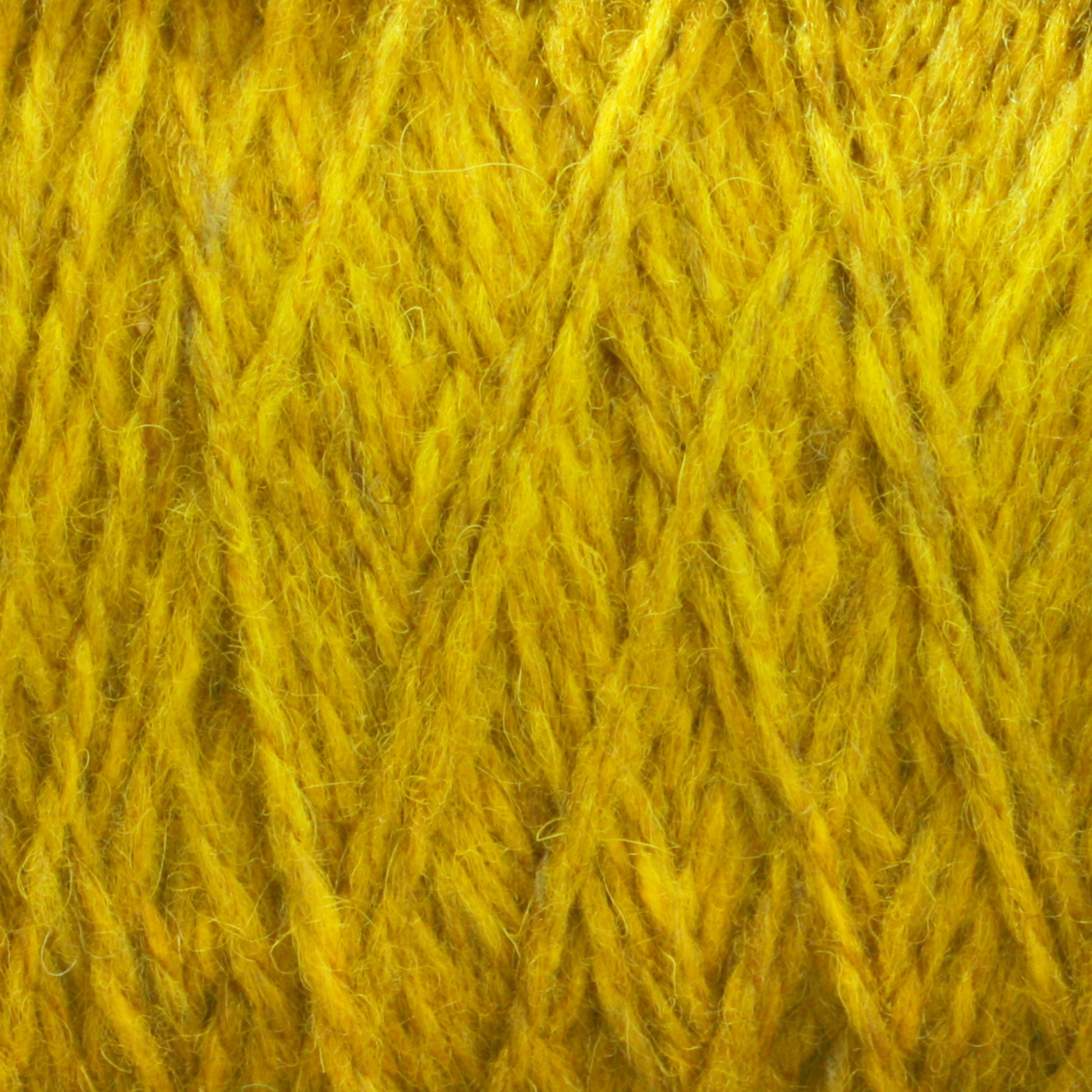 Close-up image of Harrisville Shetland Yarn - Unwashed Cones by Harrisville Designs, showcasing its fibrous and textured surface with crisscrossing strands. The yarn appears thick and is composed of many individual fibers twisted together, resembling the intricate pattern seen in Fair Isle knitting designs.