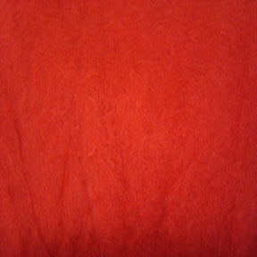 Close-up shot of a textured red fabric. The surface appears soft, slightly fuzzy, and uniform in color. The fine details of the fibers are visible, indicating a plush, cozy material akin to Harrisville Dyed & Carded Wool Fiber from Harrisville Designs.