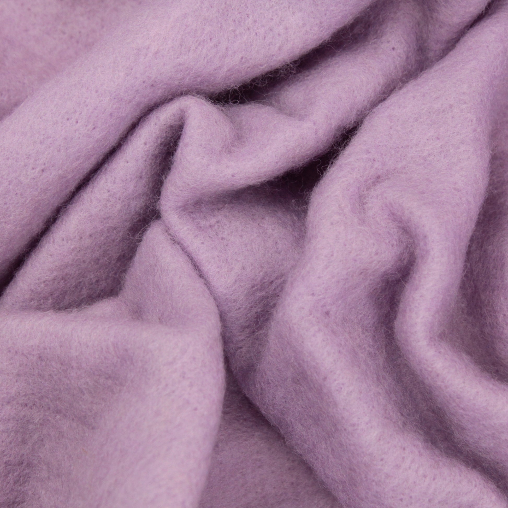 A close-up view of Europa Wools Ltd's soft, lilac-colored Merino Prefelt with gentle folds and a slightly fuzzy texture. The material appears cozy and plush, evoking a sense of warmth and comfort—ideal for nuno felting enthusiasts.