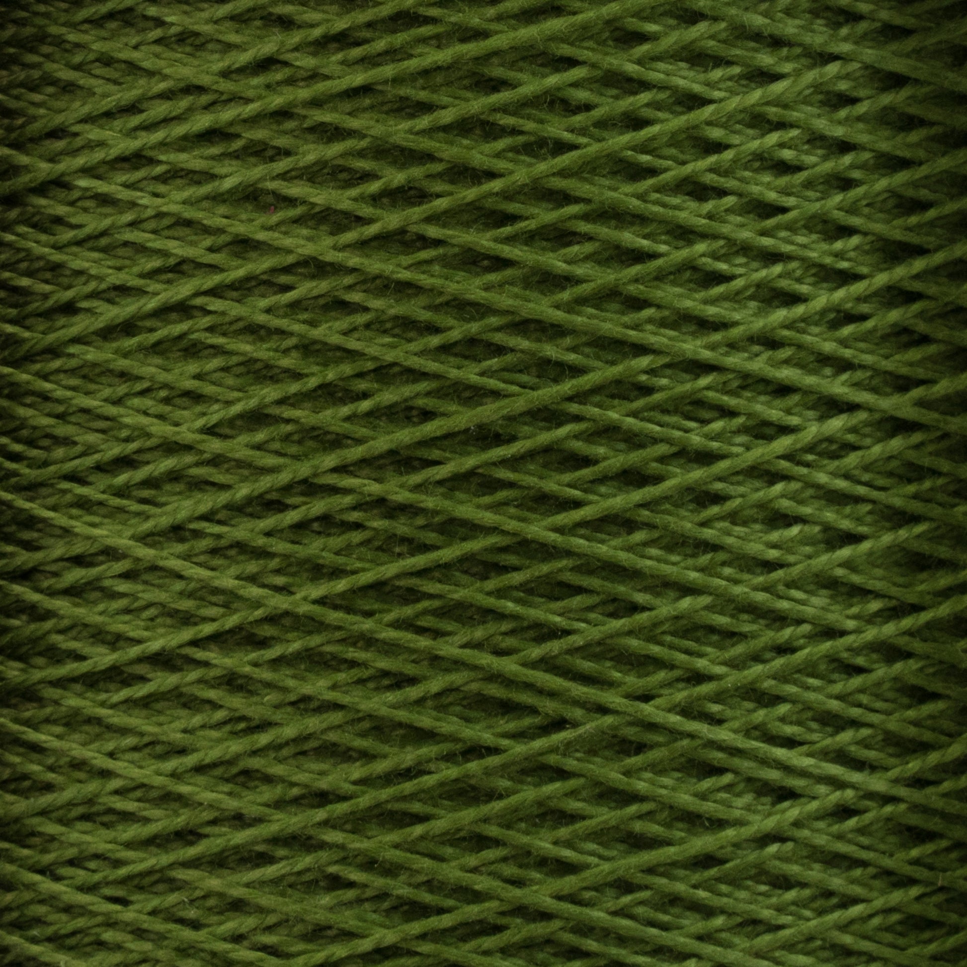 Close-up image of 10/2 Pearl Cotton Yarn by Supreme Corp., tightly wound in a crisscross pattern to form a cylindrical shape. The texture of the versatile yarn fibers is clearly visible, emphasizing the intricate detail and colorfastness of the thread in its mini-cone form.