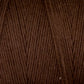 Close-up image of Maurice Brassard's Cotton 8/8 Carpet Warp in brown, showcasing tightly wound threads with a consistent texture and an emphasis on the fiber's soft appearance. Made from unmercerized cotton, this yarn is ideal for rep weave patterns as well as knitting and crochet projects.