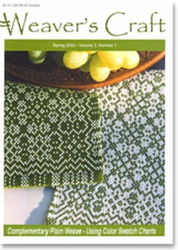 Cover of Weaver's Craft Issue 11: Complementary Plain Weave by Plain Tabby Press, Spring 2022. The cover showcases a detailed close-up of intricate green and white woven patterns, paired with a bowl of green grapes and a leaf. The headline reads, "Complementary Plain Weave - Using Color Swatch Charts.