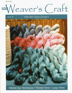 The cover of "Weaver's Craft Issue 15: Kitchen Dye Techniques" by Plain Tabby Press displays neatly arranged skeins of yarn in blue, pink, grey, and teal. To the left is a large spool of white thread. Text at the bottom highlights features such as "Kitchen Dye Techniques," "Painted Yarns," and "Loopy Yarns," perfect for weaving projects with MX-fiber reactive dye.