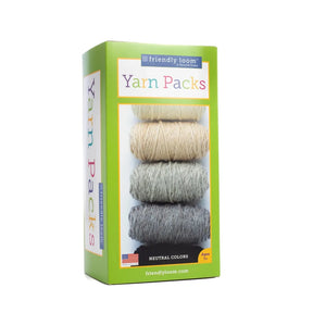 A package of Friendly Loom Lap Loom Yarn Pack featuring a stack of six balls of 100% wool yarn in neutral colors (beige, light gray, gray, and dark gray). The green packaging with colorful text states it is suitable for ages 7 and up. An American flag is displayed at the bottom.