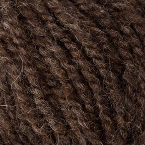 A close-up of Bartlett Maine Wool, Sport Weight Cones by Bartlettyarns reveals its textured, dark brown wool with a homespun appearance. The yarn is thick, slightly fuzzy, and features intertwined strands for a soft, natural look.