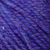 Close-up image of textured Bartlett Maine Wool, Sport Weight Cones by Bartlettyarns in purple and blue. The fibers appear soft and intertwined, creating a cozy, vibrant pattern with a charming homespun look.