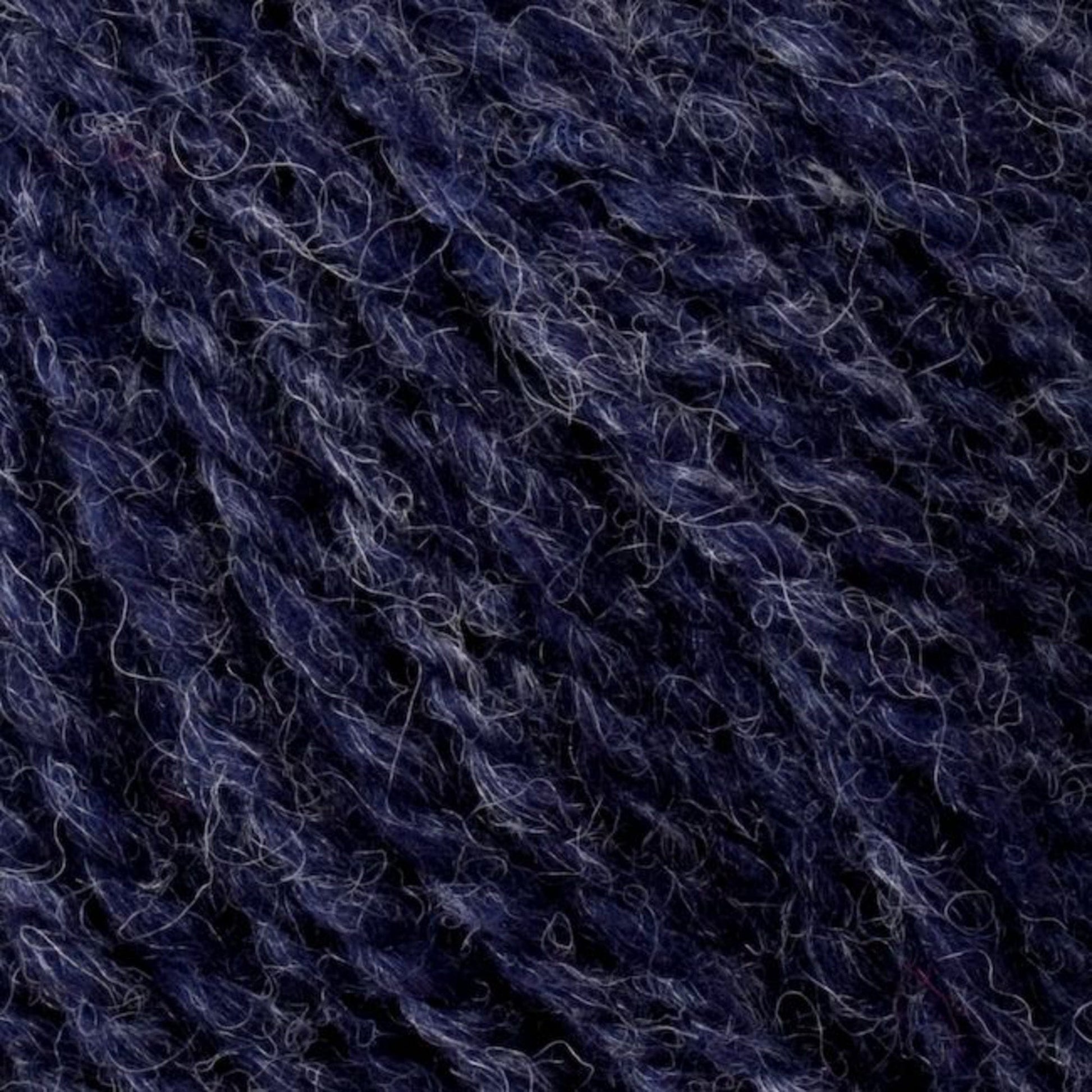 Close-up image of textured Bartlett Maine Wool, Sport Weight Cones by Bartlettyarns in deep navy blue with lighter strands interwoven, showcasing rich, intricate patterns that highlight the softness and warmth typical of sport weight wool with a charming homespun appearance.