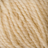 Close-up of Bartlettyarns' Bartlett Maine Wool Sport Weight Cones, featuring cream-colored yarn with a homespun look. The yarn's tightly spun fibers reveal visible texture and twists, offering a plump and cozy feel ideal for sport weight projects.