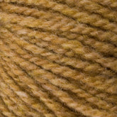 Close-up of Bartlettyarns' Bartlett Maine Wool, Sport Weight Cones revealing a homespun appearance with tightly wound fibers. The soft wool blends light and dark golden-brown shades, enhancing its cozy charm.