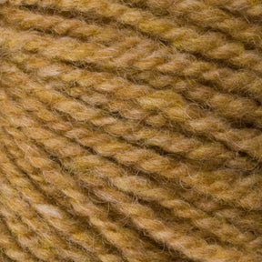 Close-up of Bartlettyarns' Bartlett Maine Wool, Sport Weight Cones revealing a homespun appearance with tightly wound fibers. The soft wool blends light and dark golden-brown shades, enhancing its cozy charm.